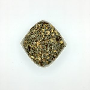 Die weiße rautenförmige Porzellanschale enthält mittelgrüne Lemongrasabschnitte und viele braune und gelbliche Gewürze.