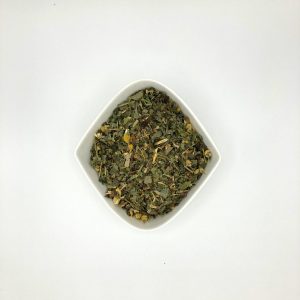 Die weiße rautenförmige Porzellanschale enthält dunkelgrüne Blattstücke mit gelben Kamillenblüten.