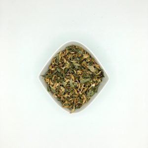 Die weiße rautenförmige Porzellanschale enthält gelb-bräunliche Blütenblätter und hellgrüne Blattstücke.