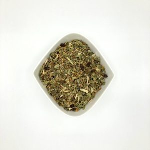 rautenförmige weiße Porzellanschale mit fein geschnittenen Kräutern und getrockneten Beeren